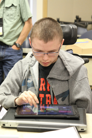 Photo of DO-IT Scholar Colton exploring tablet technology at Microsoft.