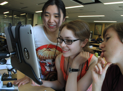 Photo of Phase I DO-IT Scholars Clarissa, Hannah, and Ellen look at a computer during an EXO Labs workshop