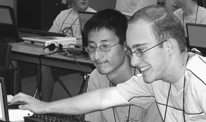 Two students using a computer Image of two students smiling while using a computer