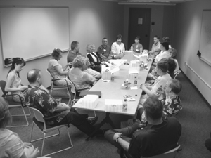 DO-IT staff have lunch around a square table. Photo of DO-IT staff having lunch around a square table.