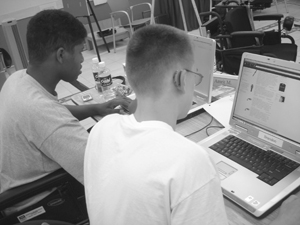 Photo of two DO-IT Scholars working on laptops in the DO-IT computer lab in between classes.