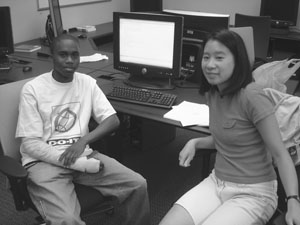 Image of two DO-IT Scholars looking away from their shared computer screen to pose for a picture