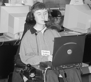 Photo of DO-IT Scholar in wheelchair typing on a computer in his lap.