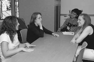 Image of Scholars and Mentors gathering around a conference table for a mock interview.