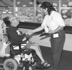 Image of a Scholar in a wheelchair receiving an award.