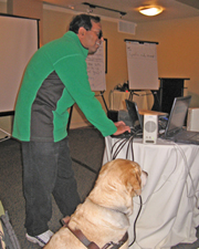 TV Raman prepares for his presentation, along side his guide dog.