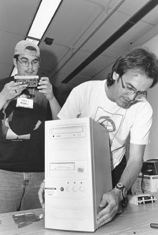 Picture of DO-IT Technology Specialist Doug and DO-IT Scholar Ryan doing maintenance to a hard drive.