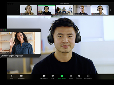 People meeting over Zoom with the pop out window showing the interpreter. People meeting over Zoom with the pop out window showing the interpreter.