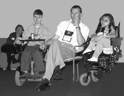 Picture of UW Vice President of Minority Affairs Dr. Rusty Barcelo, 2002 Scholar Chris, DO-IT Coordinator Michael, and 2002 Scholar Silvia watching the award presentations.