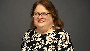 portrait photo of Amanda Snyder in black rim glasses and wearing floral print blousse
