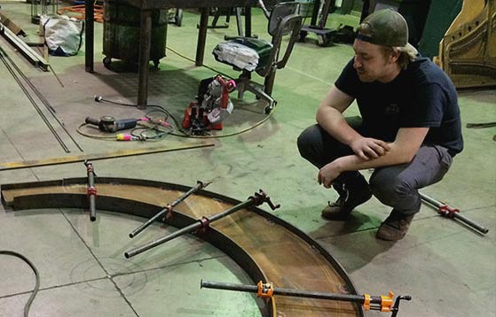 Artist using a form to build sculpture