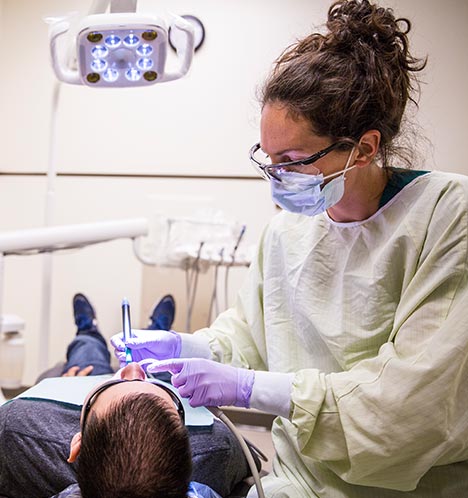 Student Meg Hurd cleans a patient’s teeth in a private exam room, which helps alleviate feelings of fear and nervousness for many patients.